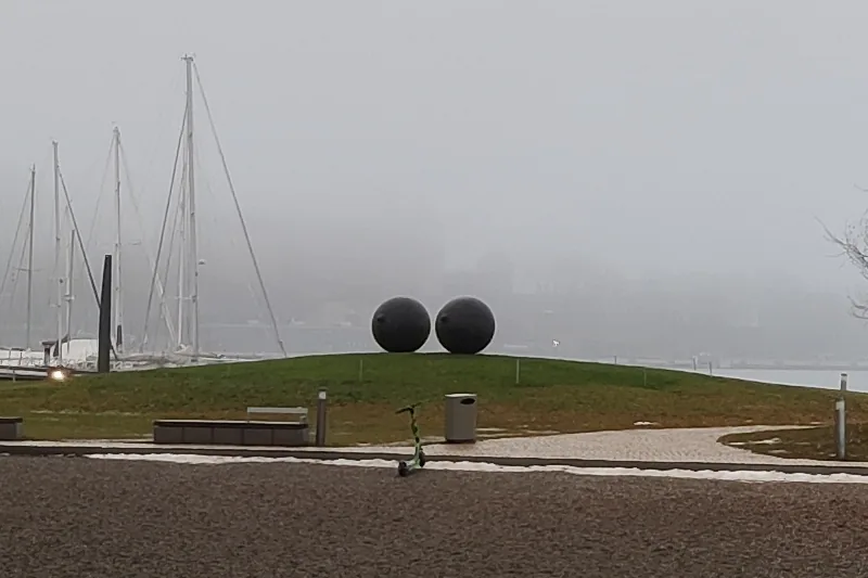 “Eyes” by Louise Bourgeois on the grassy mound on a foggy winter day, with sailboat masts behind