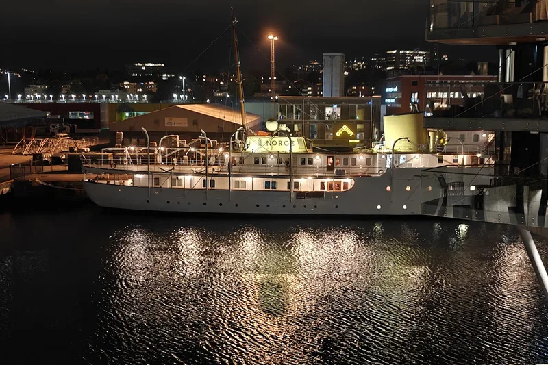 The royal yacht in the evening, its lights reflected in the water