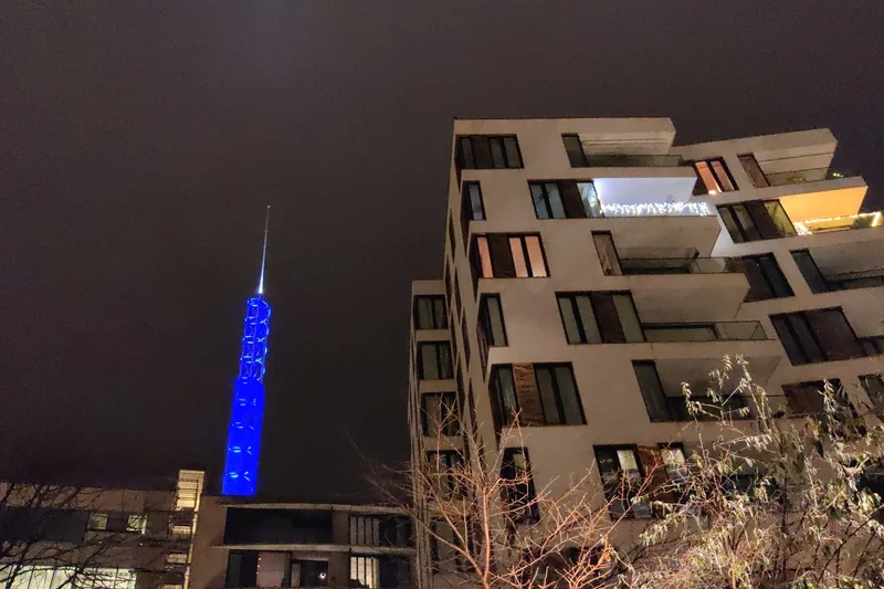 Tjuvtitten in blue light next to an apartment block on a December night