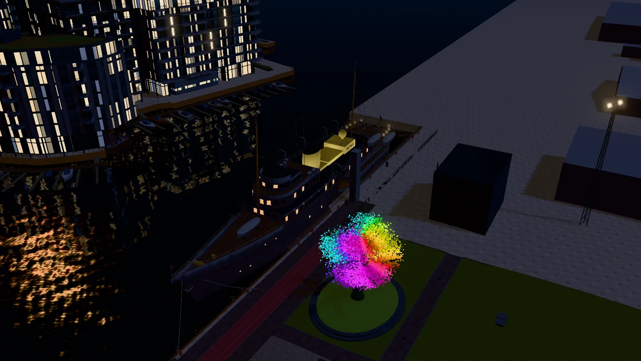 The Royal Yacht at night with lit portholes, and the Oslo Tree in bright colours beside it.