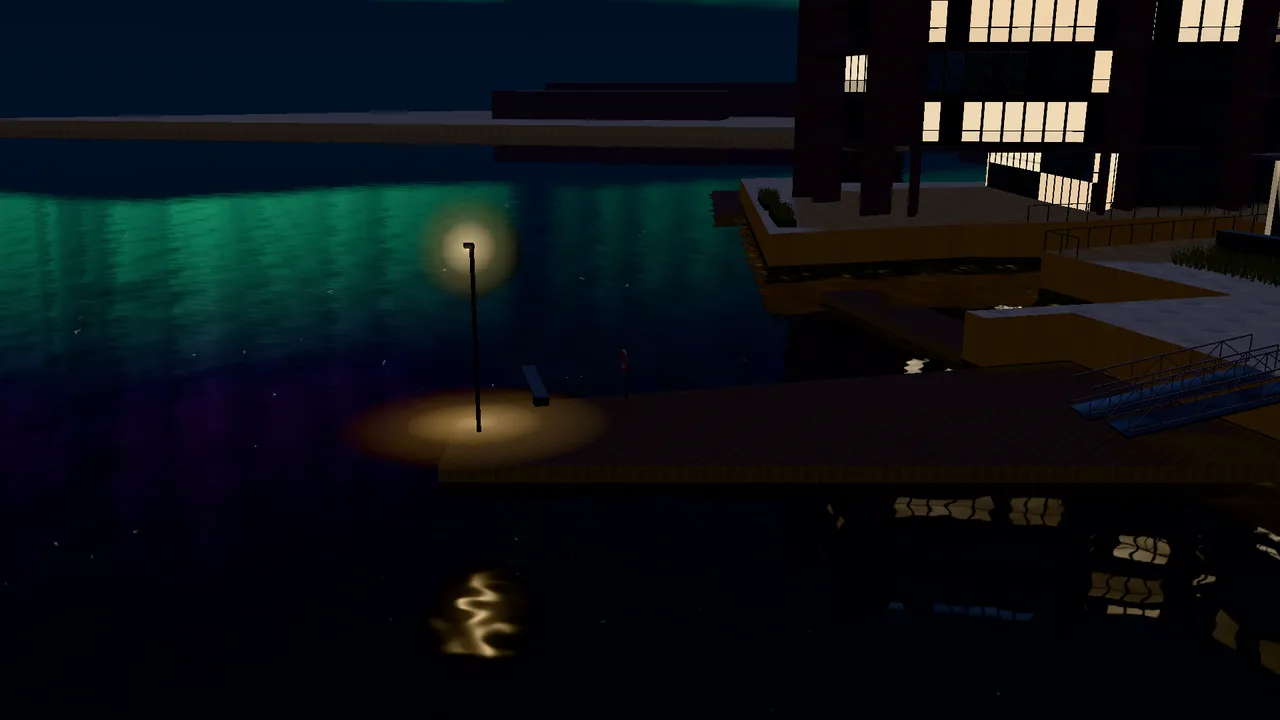 The bathing jetty at night, with a lit lamp post reflected in the water.