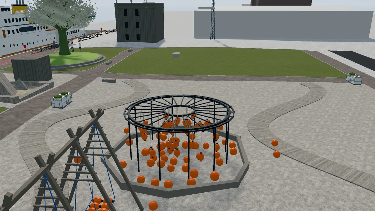 The playground in Trettenparken with a climbing frame and orange balls, and the Royal Yacht at the quay behind.
